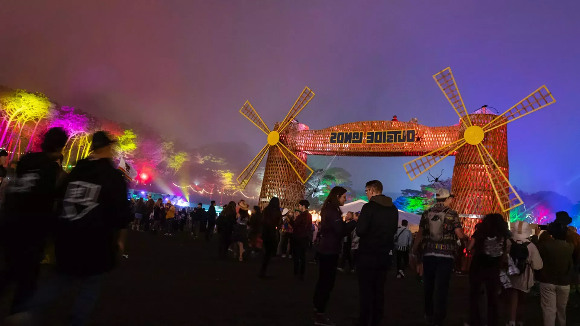 Una folla di partecipanti al festival viene fotografata di notte tra le luci al neon al festival musicale Outside Lands a San Francisco.