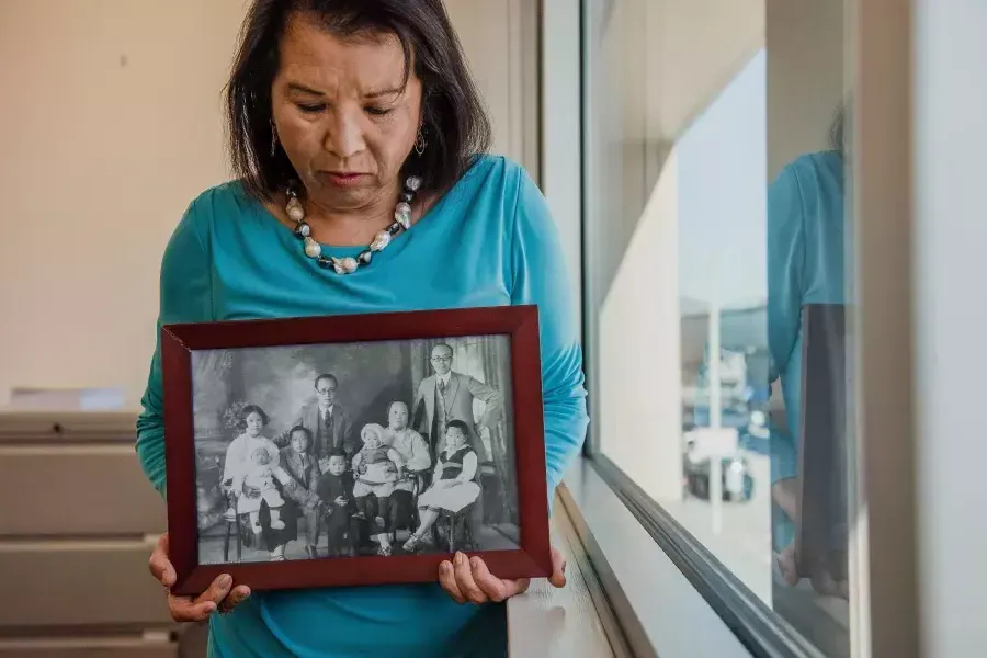 梅林达·叶富兰克林拿着她家人的照片.