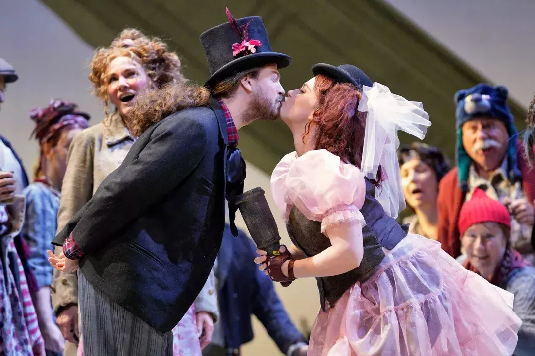 Two actors in costume kiss during a performance of Don Giovanni.