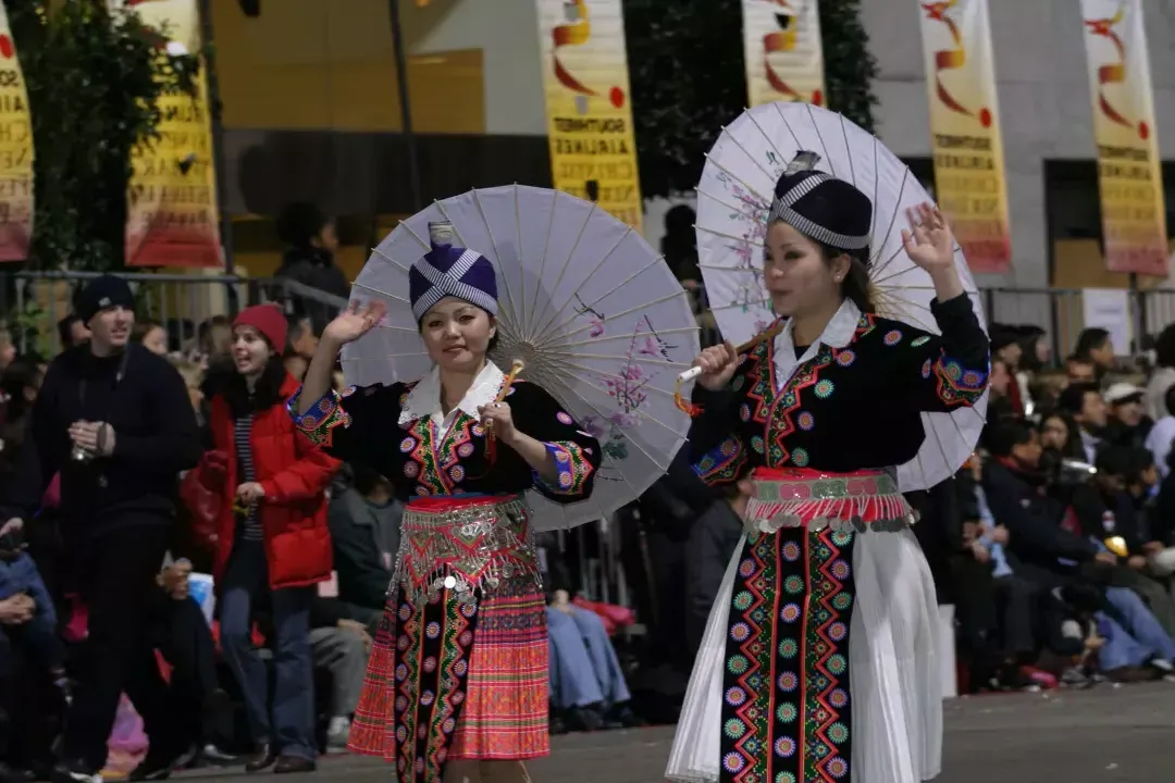 两个女人在传统服装走在贝博体彩app的中国新年庆祝游行.