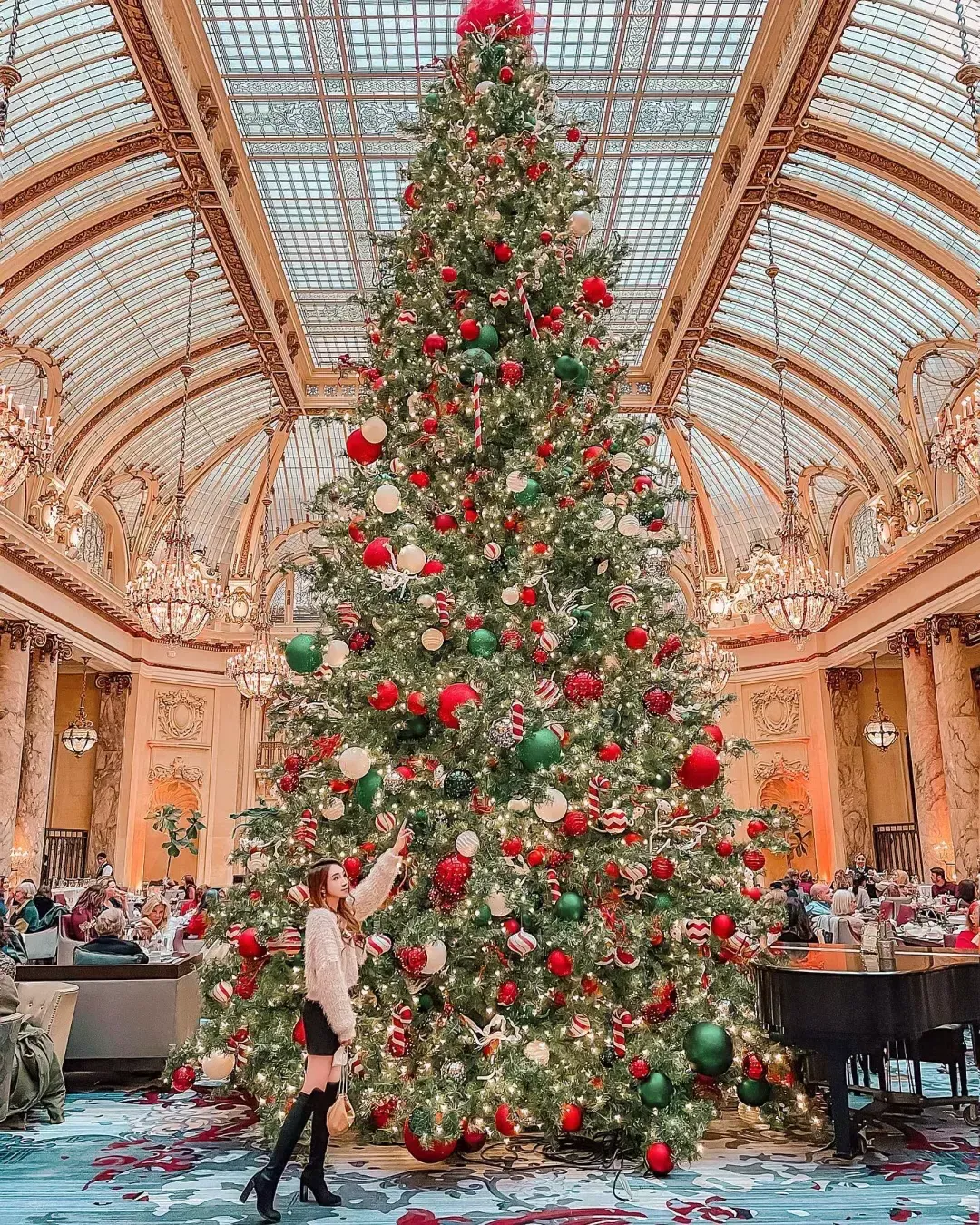 woman standing by elaborate xmas tree at Palace Hotel in San Francisco