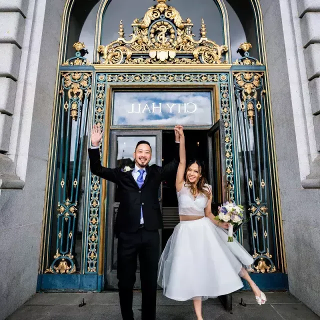 Couple posing in front of city hall after 婚礼